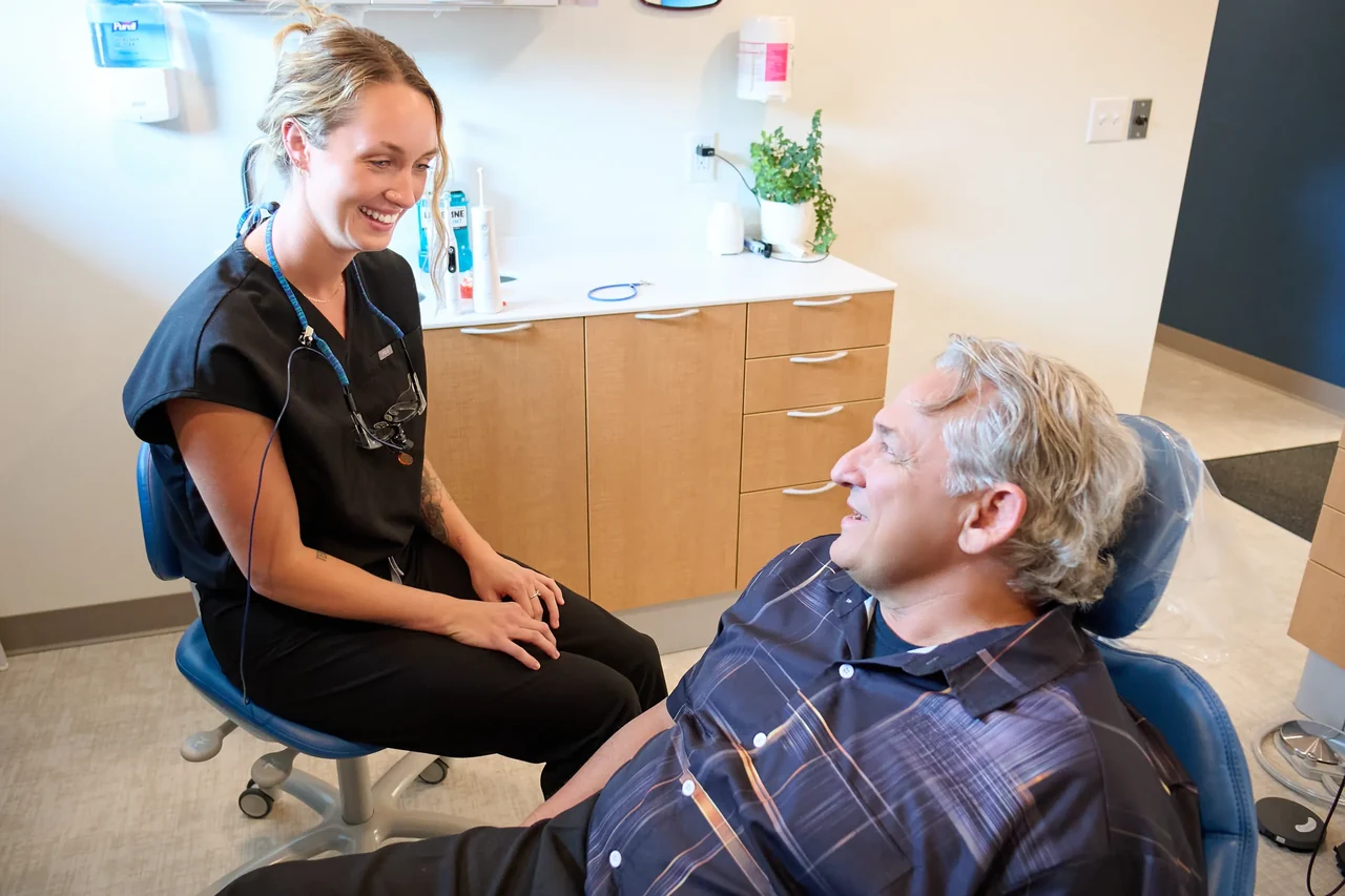 Dental hygienist reviewing a patient's care during a cleaning visit
